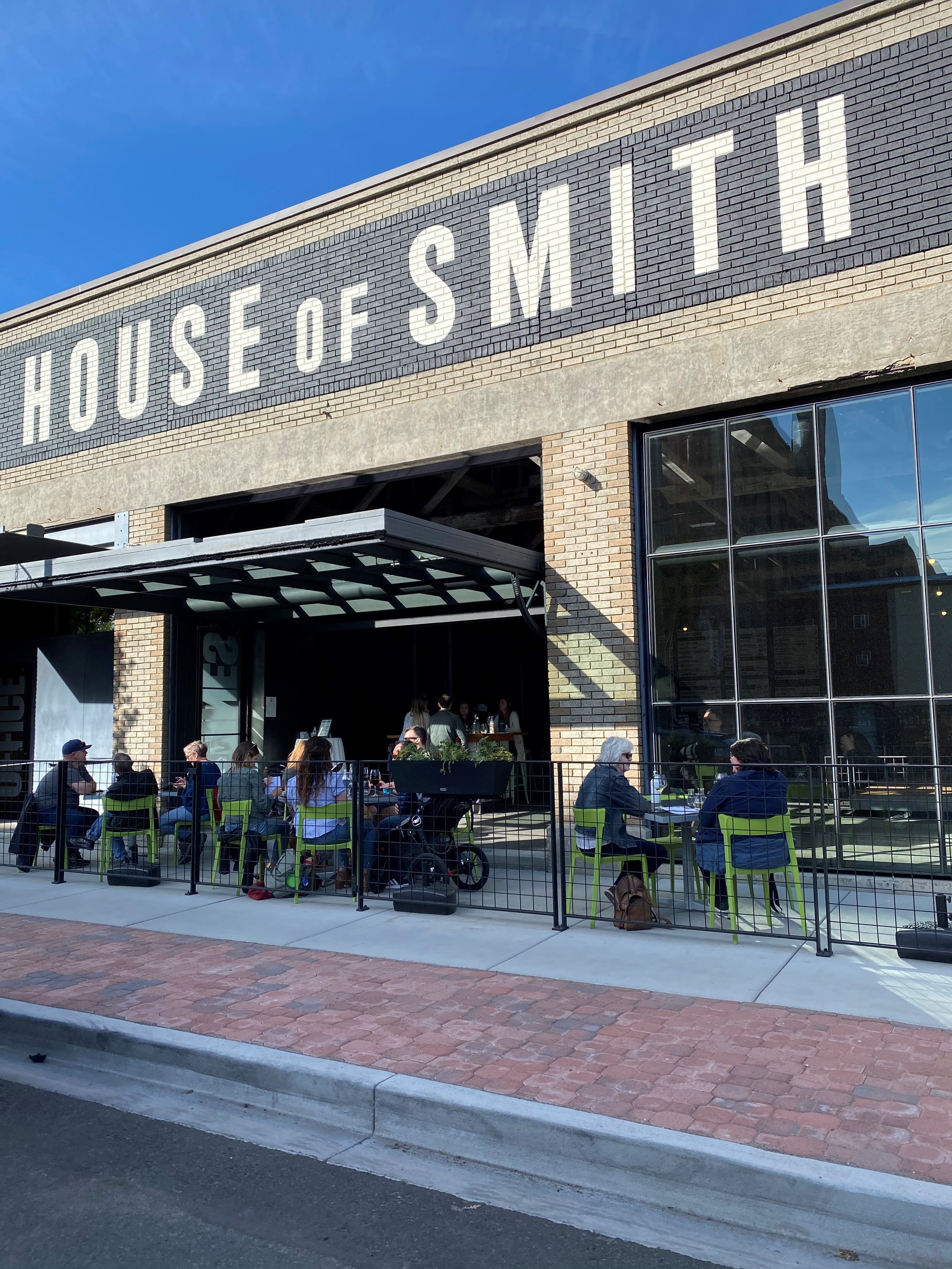 People sitting on a patio outside House of Smith restaurant