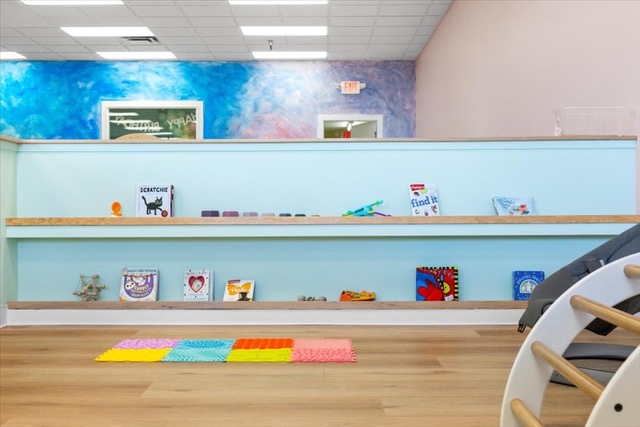 Children’s play area with books and toys displayed on low shelves