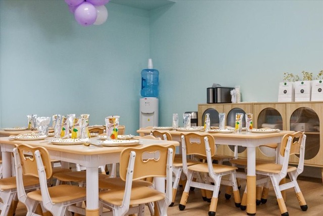 Children's party room with small tables, chairs, and party favors