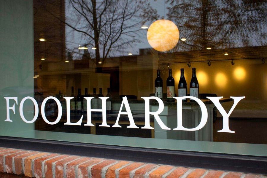 Glass storefront with “Foolhardy” in bold white letters and wine bottles visible inside.