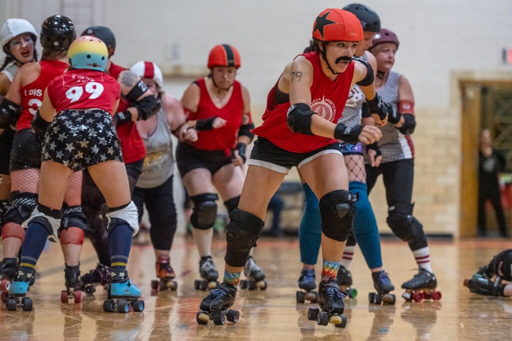 Multiple ladies on roller skates at the Walla Walla Roller Derby.