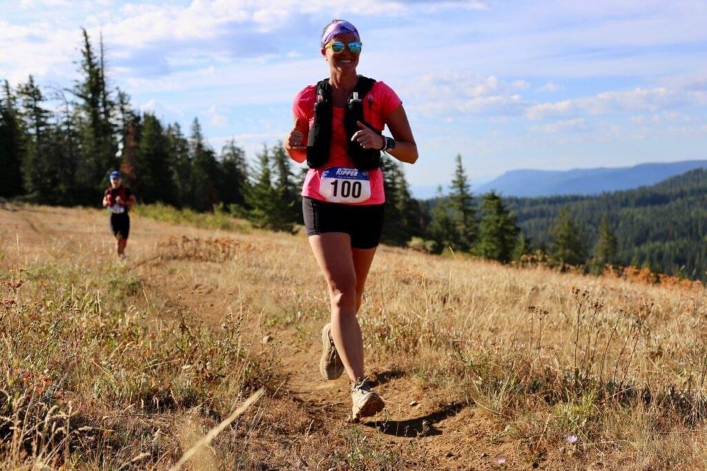 A lady competing in a Walla Walla mountain run with a gentleman not far behind her.